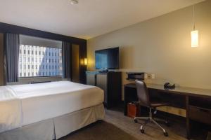 渥太华艾克酒店的酒店客房配有一张床、一张书桌和一台电脑