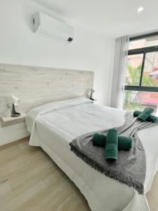 阿罗纳ISLAND SUITES的一间卧室配有一张带绿色枕头的床。