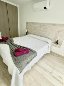 阿罗纳ISLAND SUITES的卧室配有白色的床和2条毛巾
