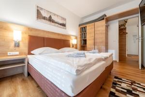 费尔德伯格Feldberg Lounge - Residenz Grafenmatt的卧室配有一张白色大床和木制床头板