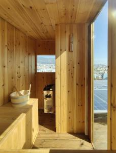 雅典Unique solar penthouse with jacuzzi and sauna in central Athens的一间带木墙的客房和一间带炉灶的厨房