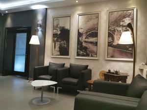 莫斯塔尔赫塞哥维纳汽车旅馆的客厅配有沙发和桌子,墙上挂有图片