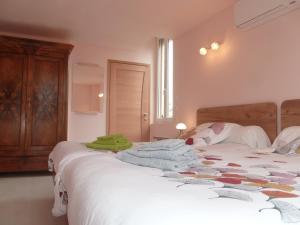 第戎L'Escale Dijonnaise的一间卧室配有两张床、白色床单和绿色毛巾