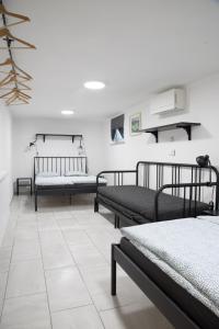多姆扎莱Apartma Licko的客房设有三张床,铺有瓷砖地板。
