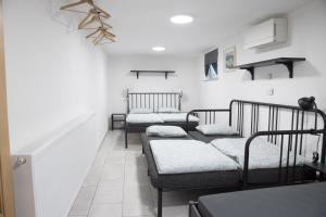 多姆扎莱Apartma Licko的白色墙壁的客房内的三张床
