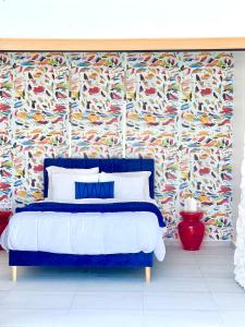 威廉斯塔德Moringa Resort - Studio A with Pool open air shower & Bath的一间卧室配有一张蓝色的床和彩色壁纸