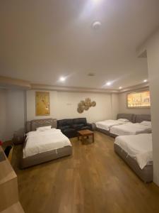 地拉那Park Hotel Tirana的带三张床和一张沙发的房间