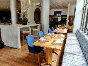 马塞约普利米尔马塞约贝斯特韦斯特酒店的餐厅设有木桌和蓝色椅子