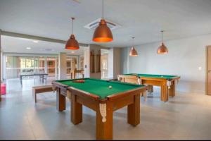 格拉玛多Golden Gramado Resort的大房间设有两张台球桌,配有乒乓球桌