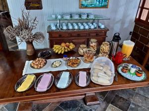 卡西米鲁-迪阿布雷乌Pousada Cascata的一张桌子上放着许多盘子的食物