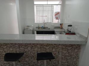 塔克纳Apartamento Amoblado en Tacna的厨房配有带2把吧台凳的吧台