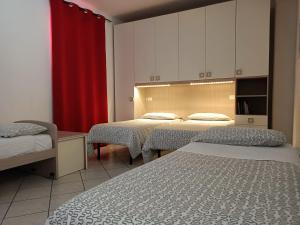 博洛尼亚Appartamenti Borghetto San Donato 105的一间设有两张床和红色窗帘的房间