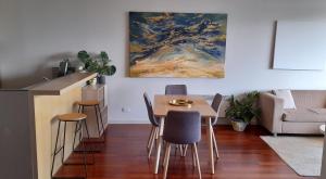 墨尔本beautiful apartment 100mts near the beach in Port Melbourne的客厅配有桌椅和绘画作品