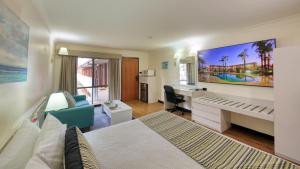 达博The Palms Dubbo的酒店客房设有一间带一张床和一张书桌的卧室