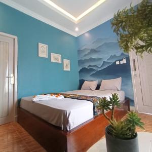 NggorangLontart Guesthouse的蓝色墙壁客房的两张床
