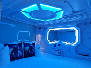 新加坡Galaxy Pods Capsule Hotel Boat Quay的蓝色的房间,配有床和电视