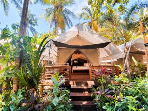 吉利特拉旺安La Cocoteraie Ecolodge - Luxury Glamping Tents的花园内带一张床和椅子的帐篷