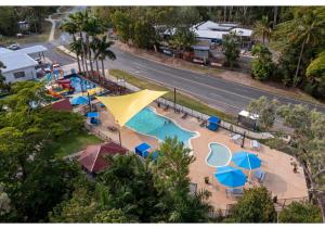 埃尔利海滩Discovery Parks - Airlie Beach的享有带遮阳伞的游泳池的空中景致