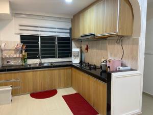 安邦Teratak Nenda的厨房配有木制橱柜、水槽和窗户。