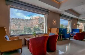 耶路撒冷金壁酒店的一间设有椅子和大窗户的等候室