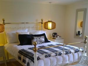 泰克利绿人精品酒店的一间卧室配有一张床、一盏灯和一面镜子