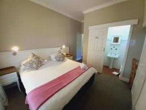 格拉罕镇137 High Street Guest House的卧室配有白色大床和水槽