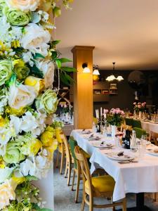 珀尔蒂尼什Pensiune Rara Paltinis的用餐室配有白色和黄色花卉的桌子