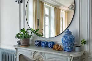 迪南Appartement de la Tour de l'Horloge de DINAN的一张桌子上的镜子,上面有蓝色花瓶