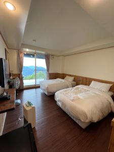 仁爱乡清境观湖四季民宿的一间卧室设有两张床、一台电视和一扇窗户。