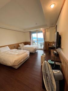 仁爱乡清境观湖四季民宿的酒店客房设有两张床和电视。
