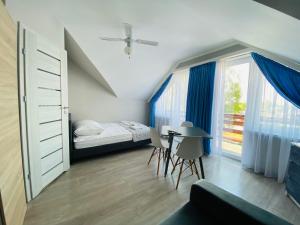 亚斯塔尔尼亚Willa Przystań的一间卧室配有一张床、一张桌子和一个窗户。