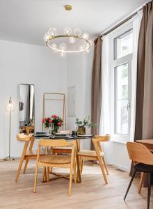 柏林Arbio I Luxury Apartments in East Side Gallery的一间带桌椅和吊灯的用餐室