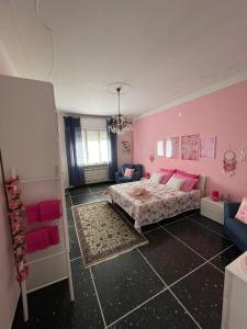 塞拉瓦莱·斯克里维亚Casa Adele的粉红色的卧室配有床和沙发