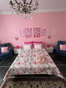 塞拉瓦莱·斯克里维亚Casa Adele的粉红色的卧室配有一张床和吊灯