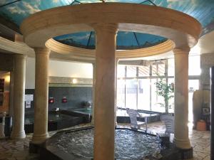 所泽市Spa胶囊旅馆（仅限男性）的一座大型游泳池,位于一座拥有大型天花板的建筑内