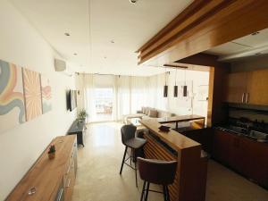 达布阿扎Peninsula Dar Bouazza Superbe appartement en résidence avec piscine activités的厨房以及带桌椅的起居室。