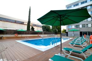 马德里阿瑟尔巴拉哈斯的一个带椅子和遮阳伞的游泳池