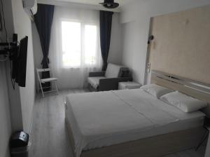 埃杰阿巴德Bahçeli Konak的卧室配有床、椅子和窗户。