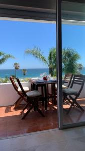 EsteponaEspectacular apartamento primera linea de playa - Golf的阳台配有桌椅