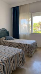 EsteponaEspectacular apartamento primera linea de playa - Golf的带窗户的客房内的两张床