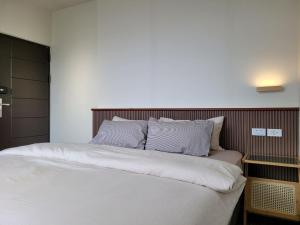 南竿好日子民宿的一间卧室配有带白色床单和枕头的床。