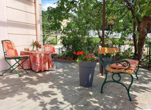奥帕提亚Room soba u Opatiji Na Lipovici的庭院设有两把椅子和一张鲜花桌子