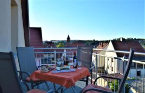 霍恩巴赫Ferienwohnung Anneliese am Stadttor的阳台配有带1瓶葡萄酒的桌子。