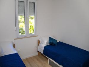默克斯卡Apartment Matea的一间卧室设有两张床和两个窗户。