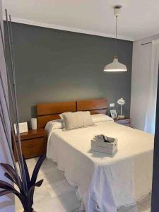 雷塔马尔Ático Parque Natural Cabo de Gata的一间卧室配有一张带白色毯子和桌子的床。