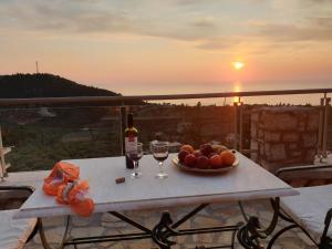 阿约斯尼奇塔斯Lavender House 1 - Agios Nikitas的一张桌子,上面放着一碗水果和酒杯