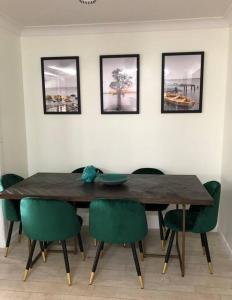 伊鲁卡Pet friendly home with pool and boat parking.的一张带绿色椅子的餐桌和墙上的照片