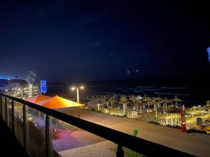 西迪布克纳德尔Luxery stay with seaview, pool, green space & Sunset orientation near Rabat的享有海滩的夜间美景,配有遮阳伞