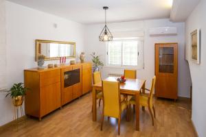 萨洛Villa PLUMA Planet Costa Dorada - ONLY FAMILIES的厨房配有木桌和黄色椅子