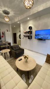 塞拉莱WASAN LUXURY RESIDENCE HAWANA Salalah的客厅配有沙发和墙上的电视